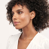 Round Diamond Bezel Front-Back Earrings in 14k Yellow Gold on woman's ear